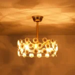 Warm glowing night view of ceramic flower ceiling fan in dark room
