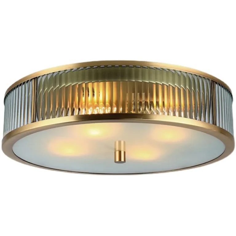Studio shot of the round modern gold bedroom light showing E26 bulb illumination.